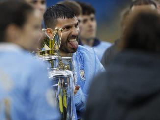 Sergio Aguero of Manchester City holds the Premier League trophy
