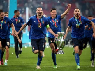 Giorgio Chiellini and Leonardo Bonucci of Italy carry the trophy