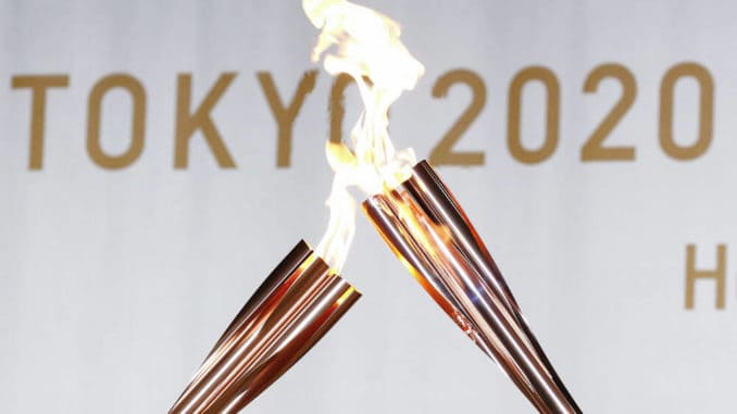Olympic flame torches kiss during a Tokyo 2020 Olympic Torch Relay event