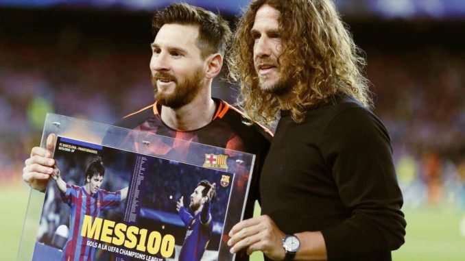 Leo Messi of FC Barcelona receives the trophy from Puyol for scoring 100 goals in UCL
