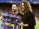 Leo Messi of FC Barcelona receives the trophy from Puyol for scoring 100 goals in UCL
