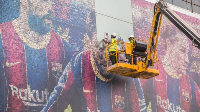 Lionel Messi's photo seen being removed from a poster at the Camp Nou
