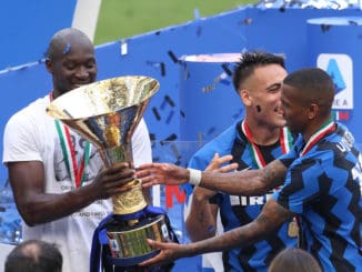 Romelu Lukaku passes the Scudetto trophy to team mate Ashley Young of Internazionale