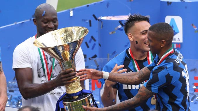 Romelu Lukaku passes the Scudetto trophy to team mate Ashley Young of Internazionale