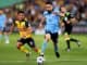 Anthony Caceres of Sydney FC competes with Josh Nisbet of Central Coast Mariners