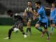 Charles M'Mombwa of the Macarthur FC competes for possession with Anthony Caceres of Sydney FC