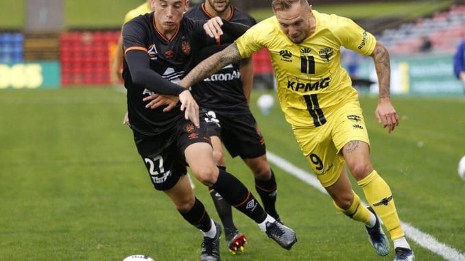 Kai Trewin of Brisbane Roar competes for the ball with David Ball of Wellington Phoenix