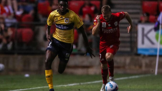 Beni Nkololo of the Central Coast Mariners breaks away from Ryan Kitto of Adelaide United